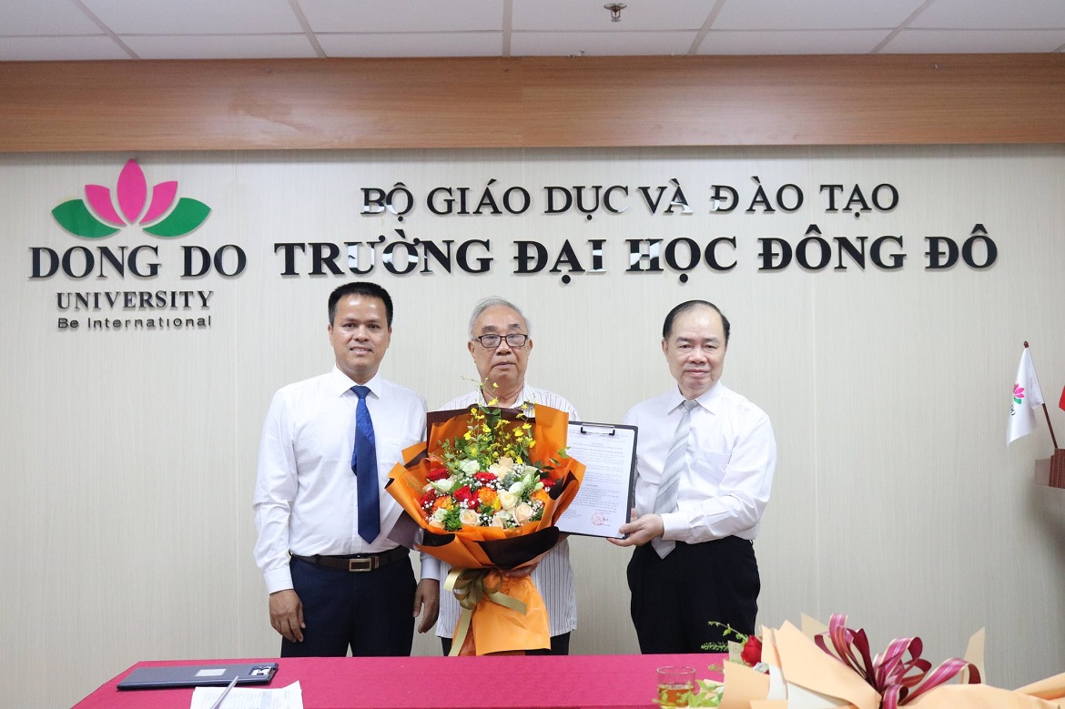 Chủ tịch Hội đồng Trường - T.S Trịnh Hữu Tuấn (b&ecirc;n tr&aacute;i) c&ugrave;ng T.S Nguyễn Th&aacute;i Sơn - Hiệu trưởng  Trường Đại học Đ&ocirc;ng Đ&ocirc; (b&ecirc;n phải) - trao quyết định v&agrave; hoa cho TS. Tạ Tiến H&ugrave;ng